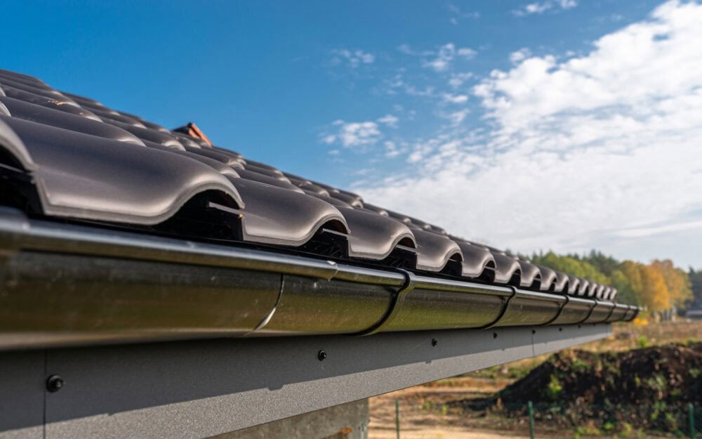 Gutter cleaning in Frenchs Forest — new metal gutter along a charcoal tile roof